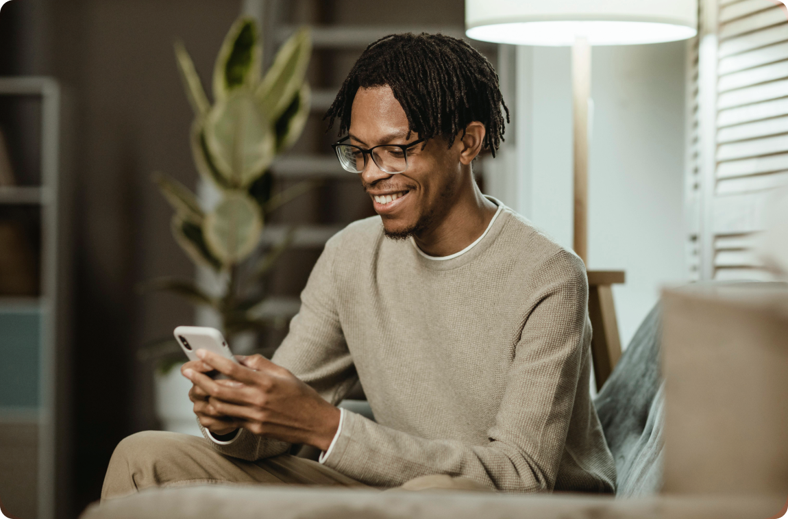 homem-negro-sorrindo-mexendo-no-celular